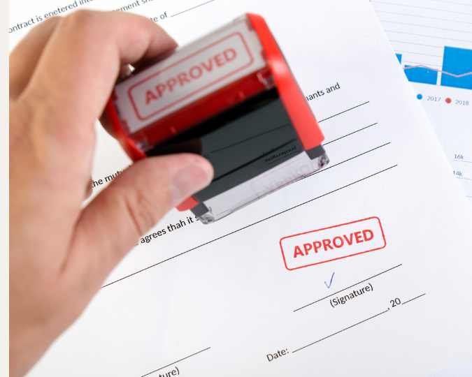 Baubewilligung Mehrfamilienhaus Schweiz – Stempel mit „APPROVED“ auf offiziellem Dokument.